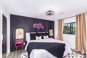 The glamorous master bedroom features a custom neon sign, because what girl doesn't want to feel like they're like, really pretty?!