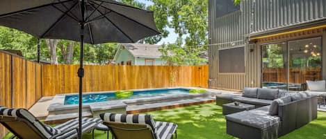 Backyard with pool, plenty of patio furniture, corn hole & string lights