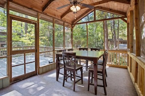 View of our screened in back porch and outdoor eating area.  The screened in porch looks out to the private outdoor oasis.