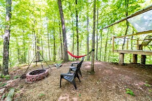 Outside are of the tent with lounge area, fire pit, and hammock. 