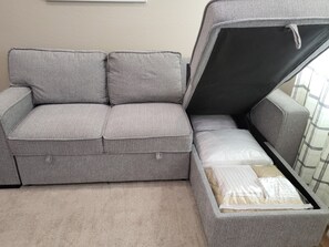Sofa storage with extra sheets, pillows and blanket 