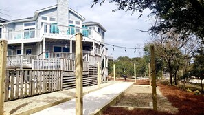 Lighted bocce/cornhole/horsehoe courtyard under live oaks