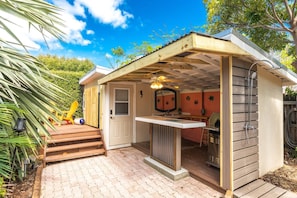 Relax poolside under the covered patio, complete with a grill and bar area, for the ultimate outdoor dining and entertainment experience.