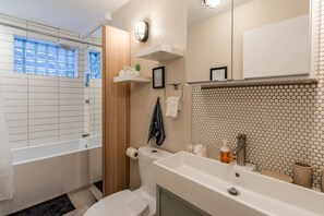 Luxurious 4-piece bathroom with in-floor heating, fresh towels, and premium toiletries for a spa-like experience