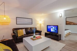 Modern chic living room with a comfortable futon, stylish decor, and a 42-inch smart TV—perfect for unwinding after a busy day