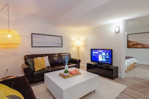 Modern chic living room with a comfortable futon, stylish decor, and a 42-inch smart TV—perfect for unwinding after a busy day