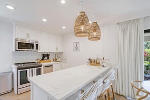 In the dining area, barstools at the kitchen peninsula supplement seating at the dining table for four