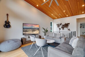 Living room on top floor adjacent to covered deck and folding door.