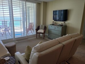 Living area with built-in recliners. Emerald green waters seen past the balcony 