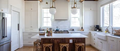 Designer kitchen with marble countertops, farmhouse sink, and Bosch appliances.