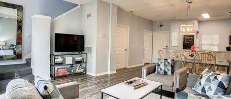 Open plan living area with dining area and kitchen in the background