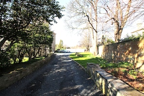 The sun-dappled private driveway leading to the parking area & entrance.