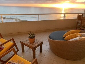 The balcony stretches the length of the  apartment with comfy, designer loungers