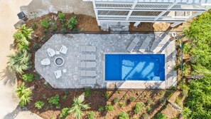 Stunning fenced in private pool with lounge chairs and established landscaping