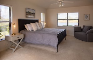 Primary suite with king bed, lake view and pool access. Full bath, shower & tub.