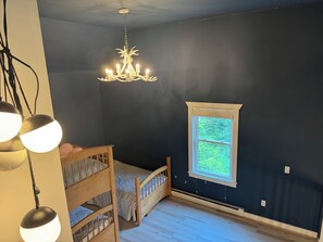 Landing: bunk bed, twin bed, 3 twins total, with modern antler chandelier