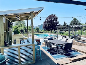 Outdoor pool bar with speakers and TV.