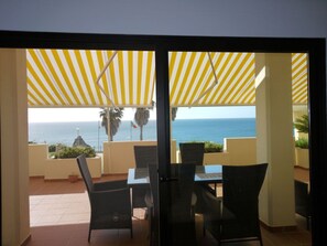 Dining table on the terrace in the shade of the awning
