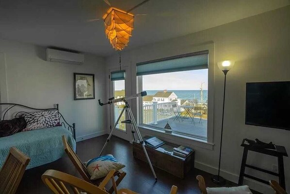 Ocean view room with kitchenette, day bed, cork floor, TV, and deck.