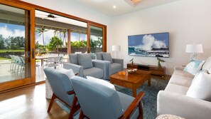 Living room with large UltraHD TV and pocket doors leading to lanai