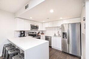 Upgraded kitchen with quartz counters and quality appliances.