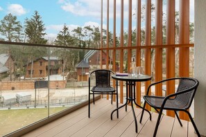 Furnished balcony with green surroundings. 