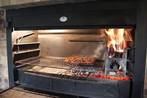 Wood burning braai/barbeque in braai room.