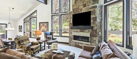 Open concept seating area with cable tv, fireplace, and floor to ceiling windows