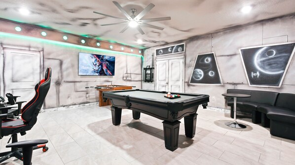 Star Wars-themed game room with pool, foosball, gaming chairs, and epic decor!
