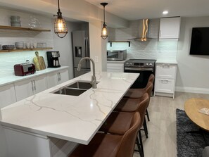 Double sink! Caesar stone counter, floating shelves, loads of cupboards!