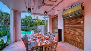 Outdoor Dining in lanai with flat screen television and table side fridge to keep your beverages frosty!