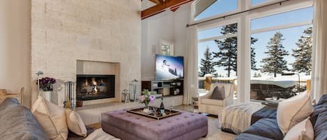 Main Level Living Room with over-sized sectional and sofa, 65" Samsung TV, vaulted ceilings, gas-assist fireplace, private deck access, billiard table, and stunning views of the surrounding mountains