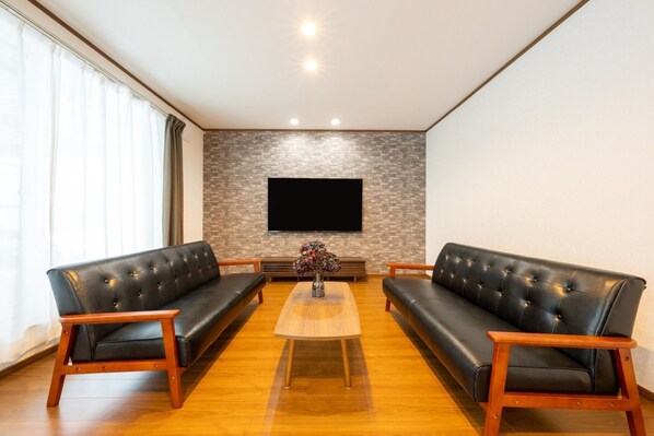 A spacious and fashionable living room. By installing a 65-inch TV, you can get together.