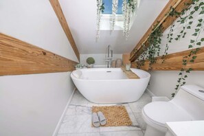 A rainfall shower and a soaking tub with skylight
