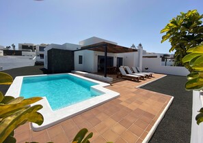 Large terrace with outdoor furniture and private pool heated by heat pump