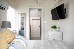 The upstairs bedroom feels like a tree house with a comfortable mattress, smart TV, and an en suite. 