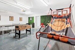 large indoor game room with basketball arcade game, ping pong table, 3-in-1 game