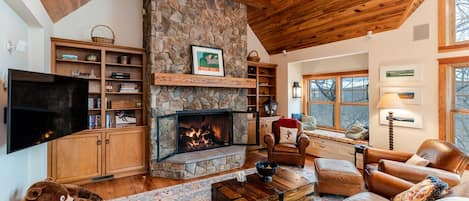 Cozy seating area with fireplace, leather furniture, upholstered window seat