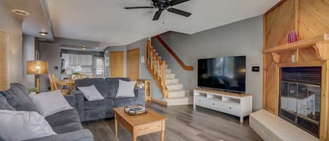 Living room with couch, loveseat, reclining chair and smart TV. (Due to code, fireplace is not available for guest use.)