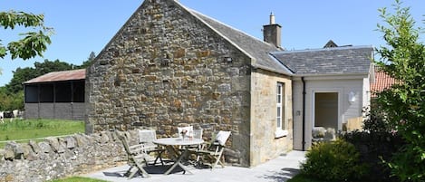 Fordel Cottage - external view of the cottage with pretty farm buildings nearby and horses in the surrounding fields