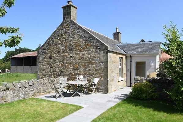 Fordel Cottage - external view of the cottage with pretty farm buildings nearby and horses in the surrounding fields