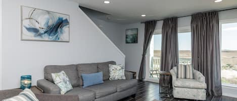 Newly remodeled living area with queen size sleeper sofa and partial beach view from balcony