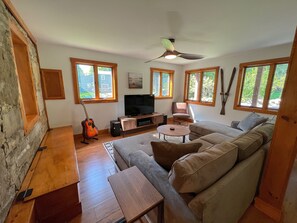 Inviting, comfortable living room with large couch, record player and Smart TV