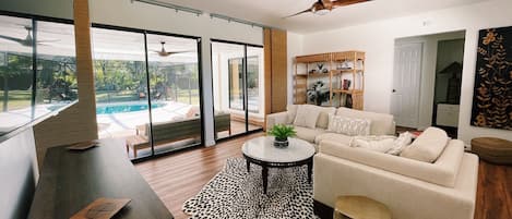 Living room looking out to the pool and screened lanai w/ 2 sliding glass doors