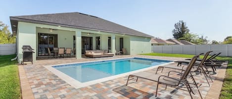 Unwind in the private backyard with a heated, south-facing saltwater pool. The patio is designed for your comfort with lounge and dining areas, covered cooking space, and a Weber gas grill.