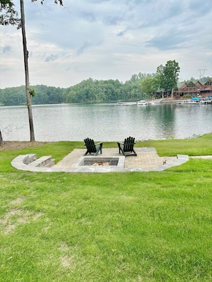 Large green lawn and lakeside patio/firepit area.