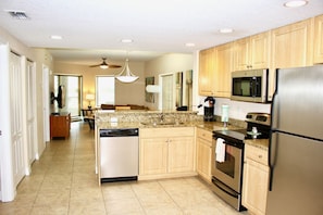 Fully equipped kitchen with fridge, microwave, stove, oven and dishwasher.