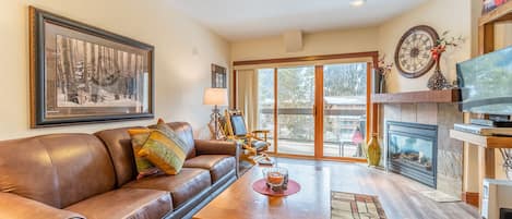 Living area with smart TV, fire place and access to private balcony.