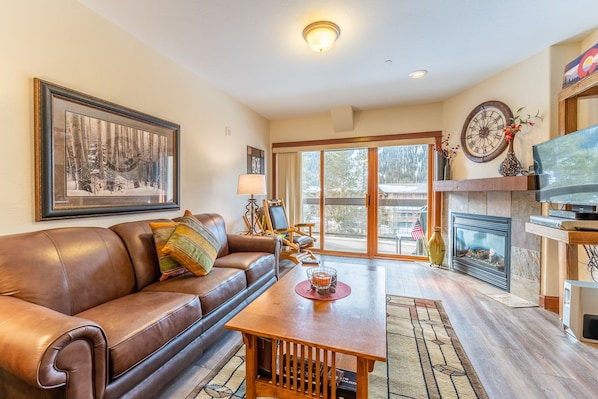 Living area with smart TV, fire place and access to private balcony.