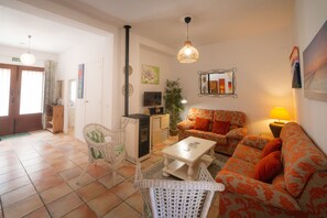 The living room has seating for six people, a Smart TV, stereo & pellet fire